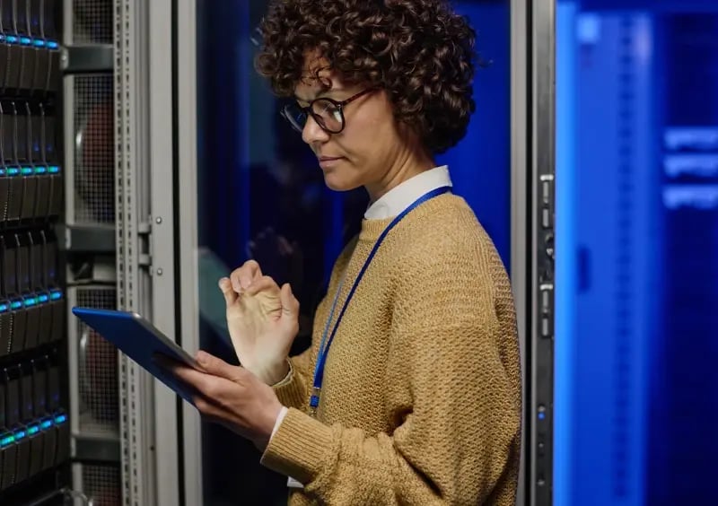 An IT professional inspecting the server room