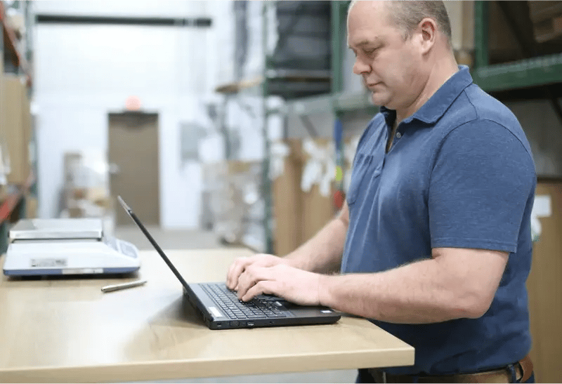 Man using laptop on workbench