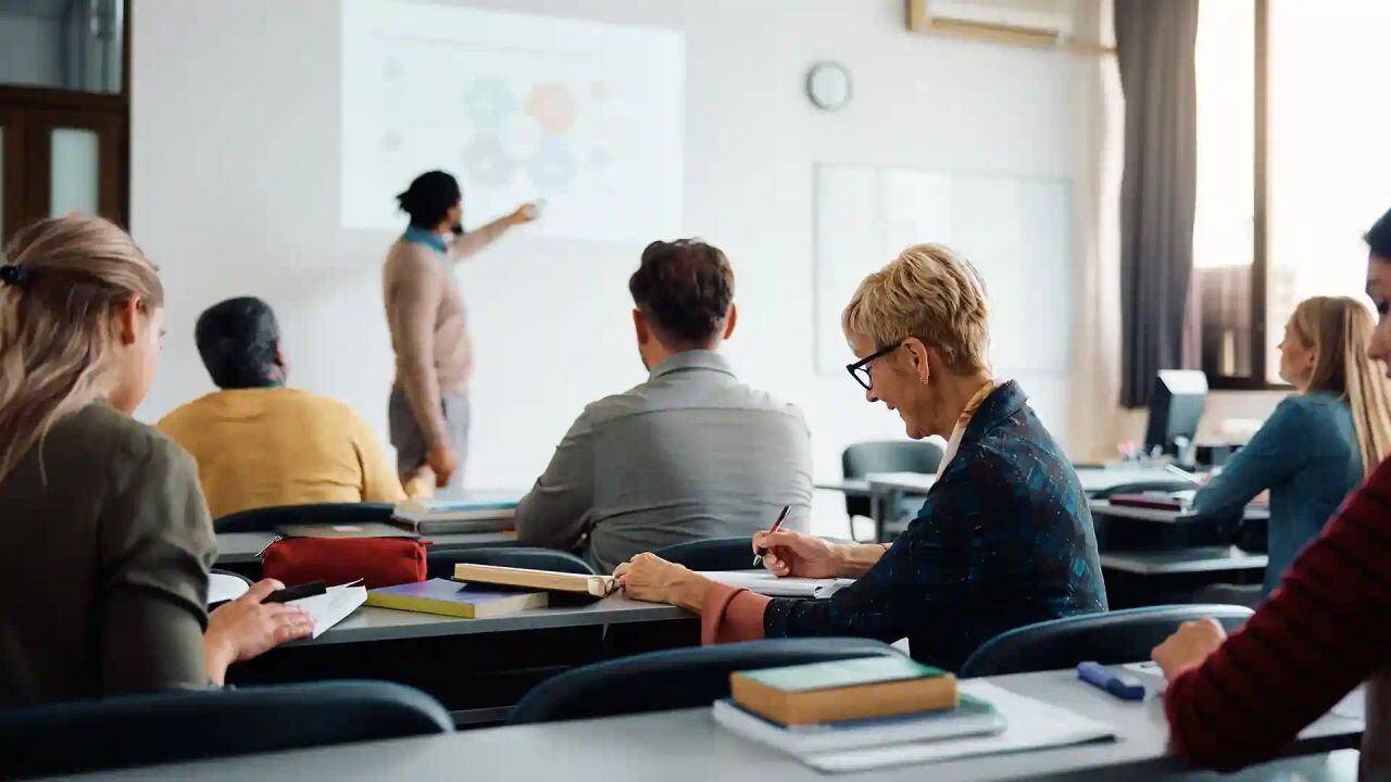 Inside a classroom where students are taking notes while teacher lecturing