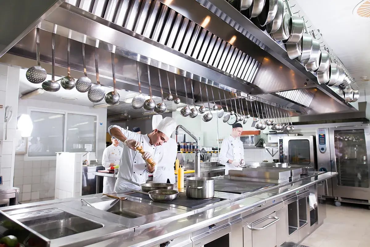 restaurant kitchen image with cook in background