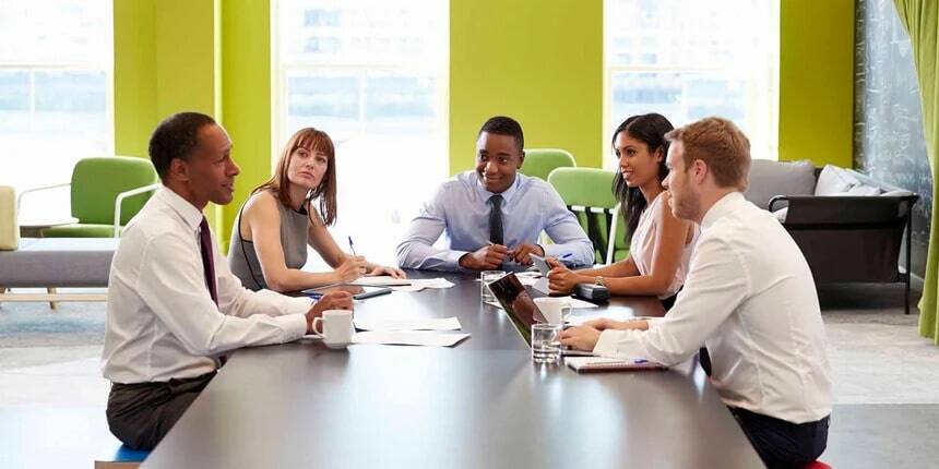 Employee using meeting room and desk booking software to connect with colleagues in an office setting.