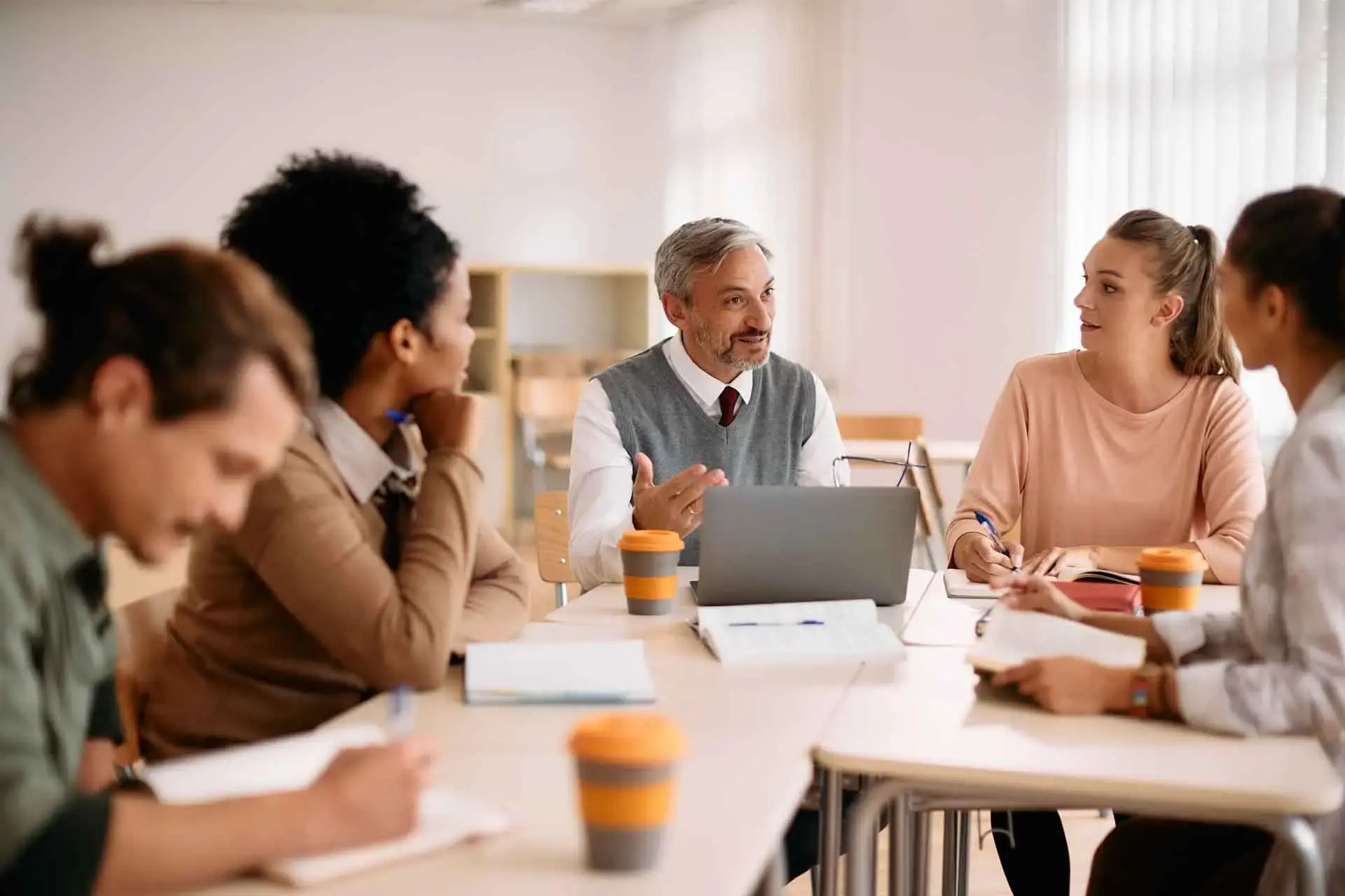 A group of professor and students discussing a project in a Higher Education Institution