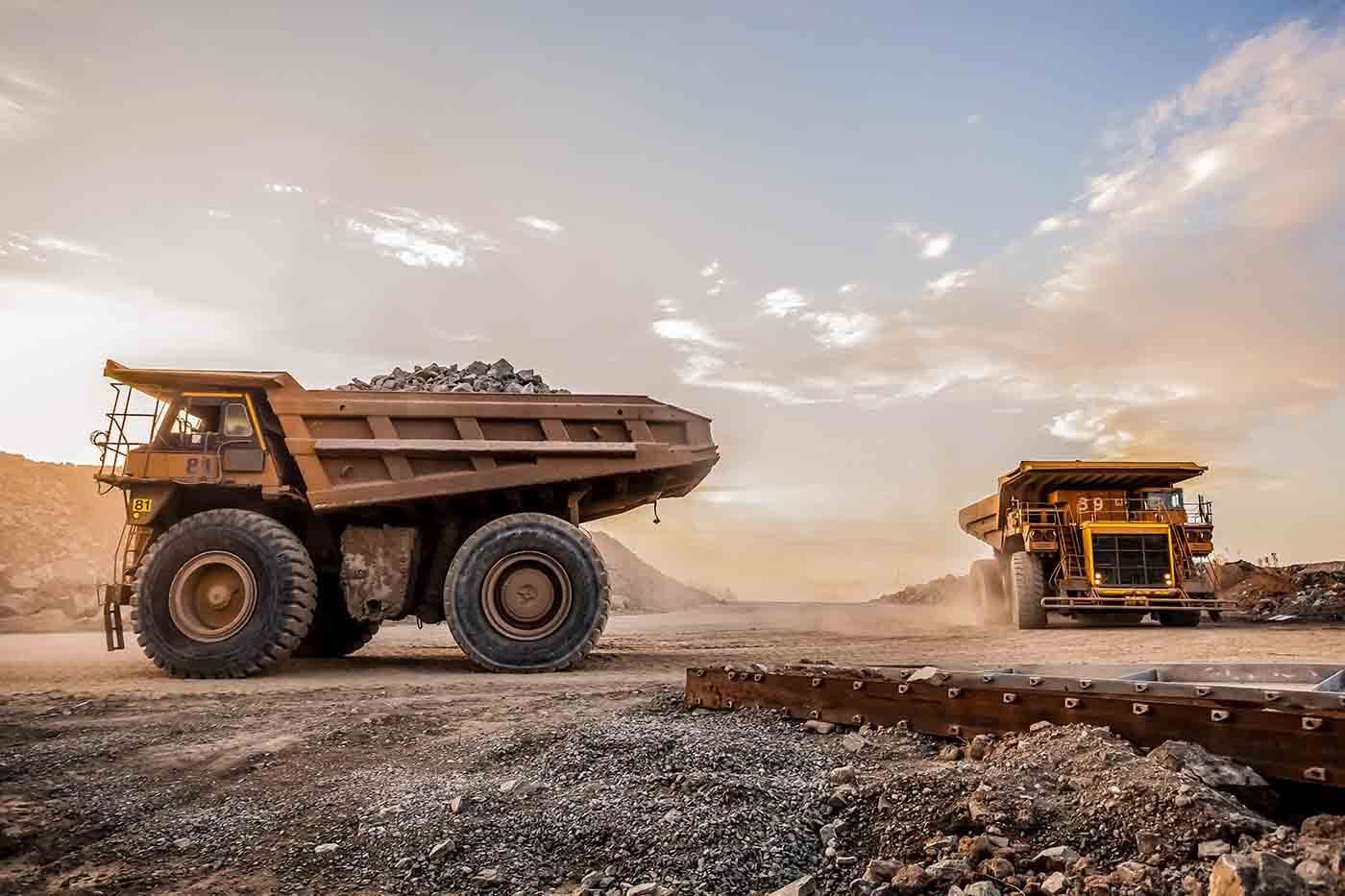 Two large dump trucks working in a mining site