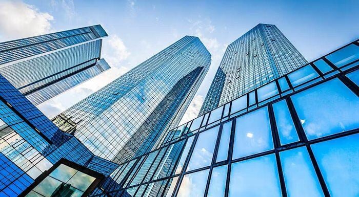 Modern glass skyscrapers reflecting the blue sky and clouds