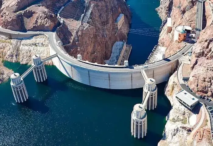 Aerial view of the Hoover Dam with water and surrounding rocky landscape