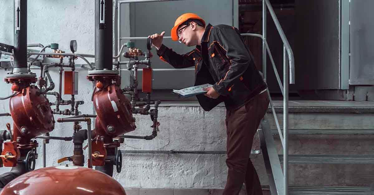 A technician inspects industrial equipment