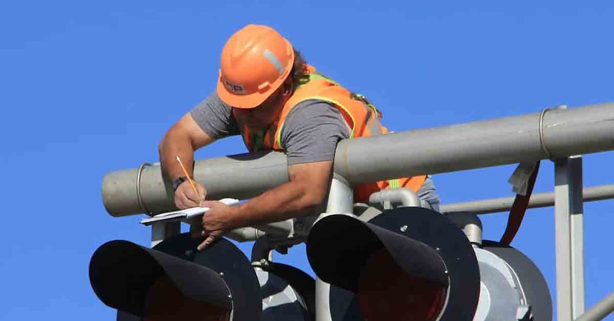 Worker conducting routine maintenance on equipment, ensuring functionality and safety with checklists, and protective gear.