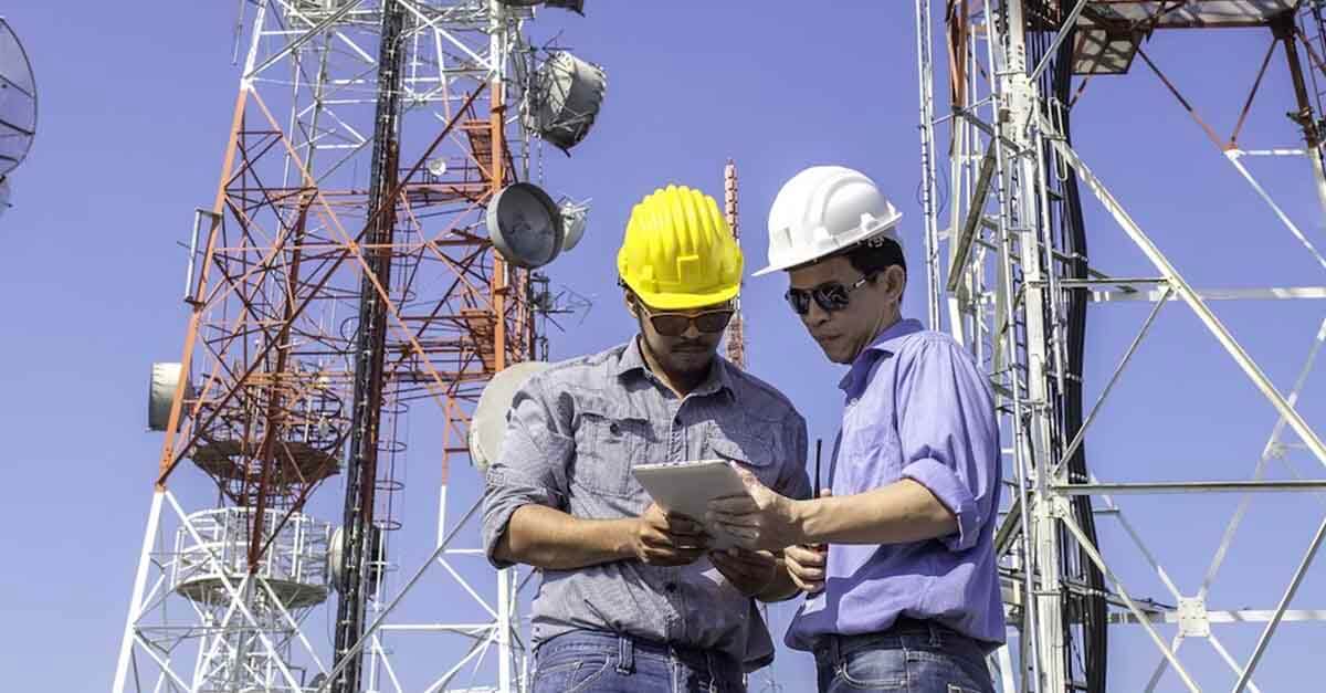 Two engineers in hard hats examining Siterra Site Lifecycle Management tool