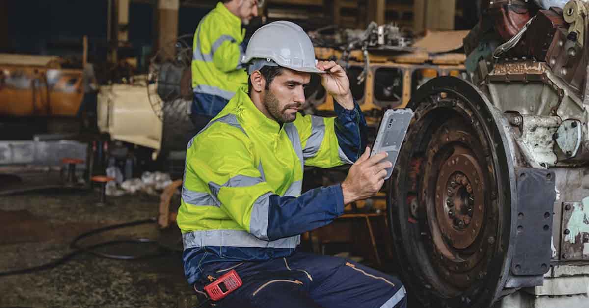 Engineer in safety gear inspecting machinery