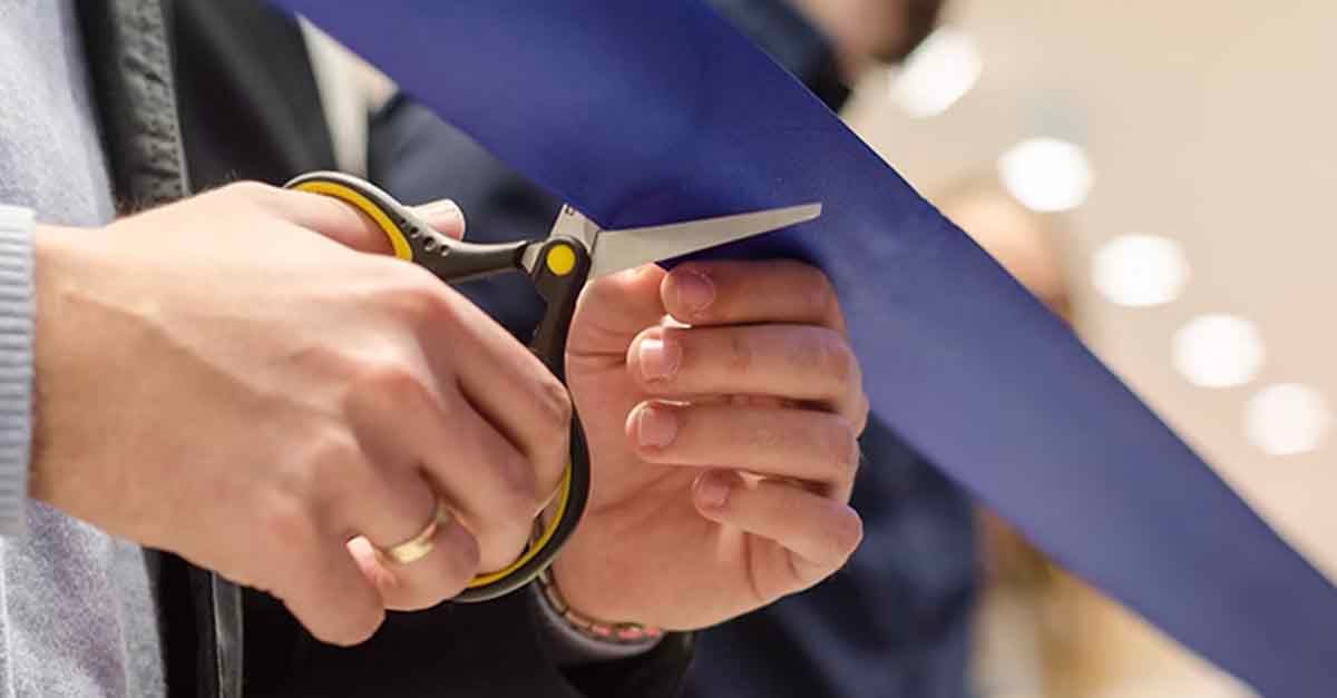 A person cutting a blue ribbon kicking off project with Lucernex