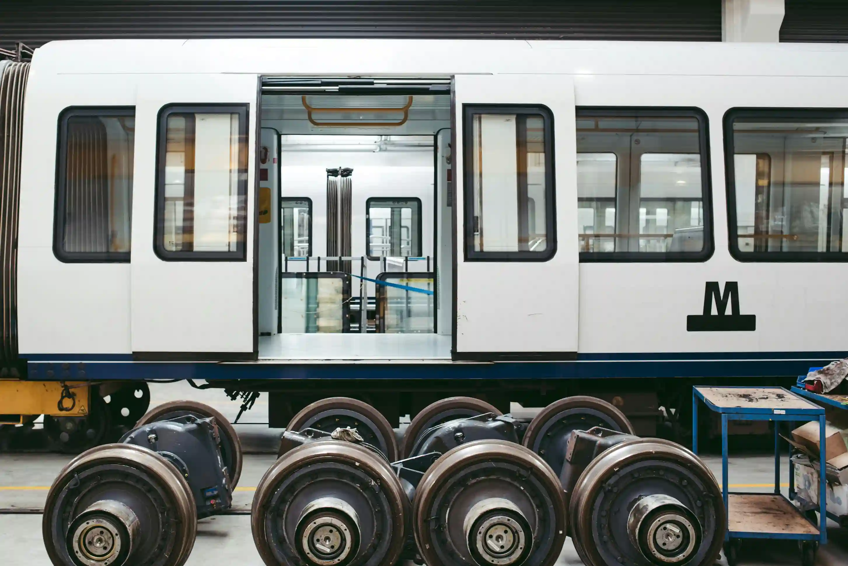 Subway train under maintenance with wheels removed and tools nearby