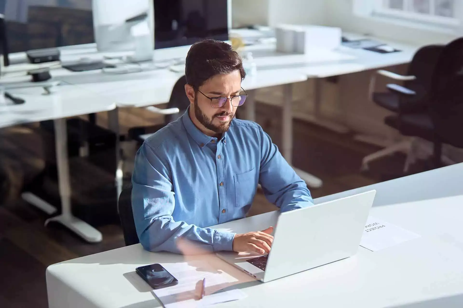 A business professional managing work on his laptop, utilizing Lx Contracts