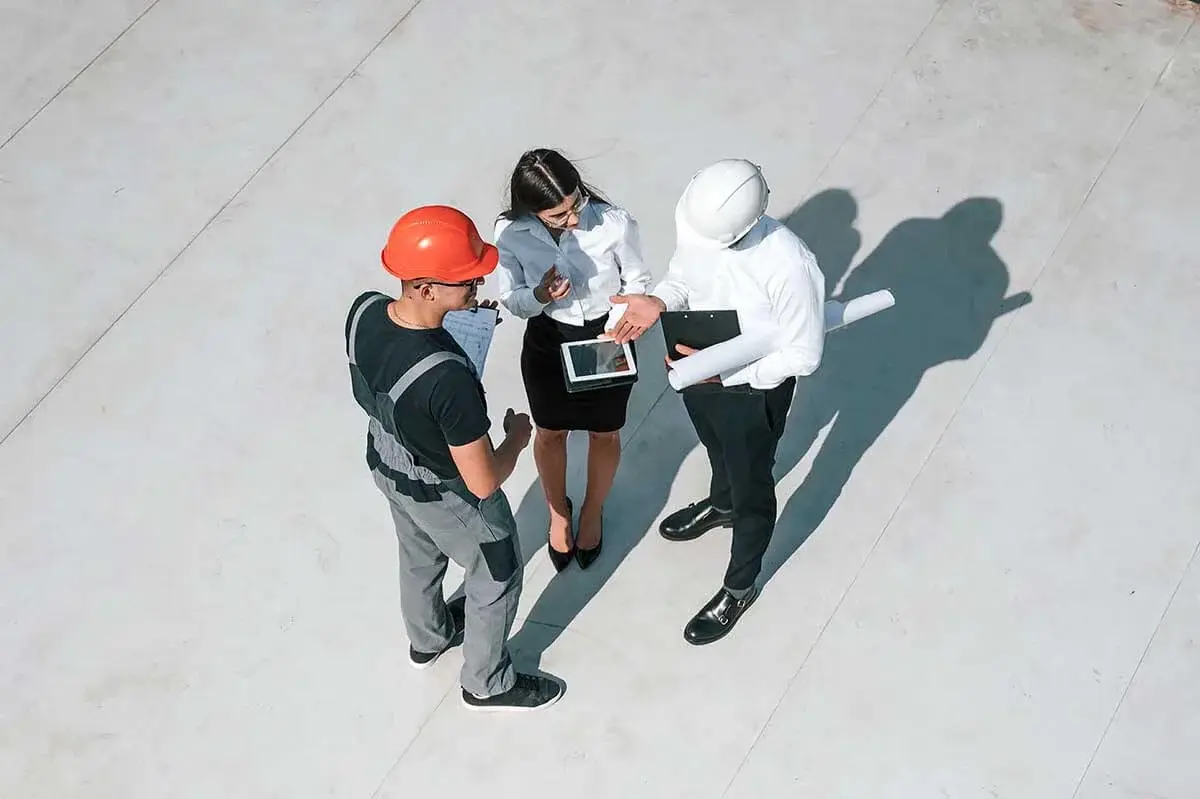 a group of construction engineers discussing project on a tablet