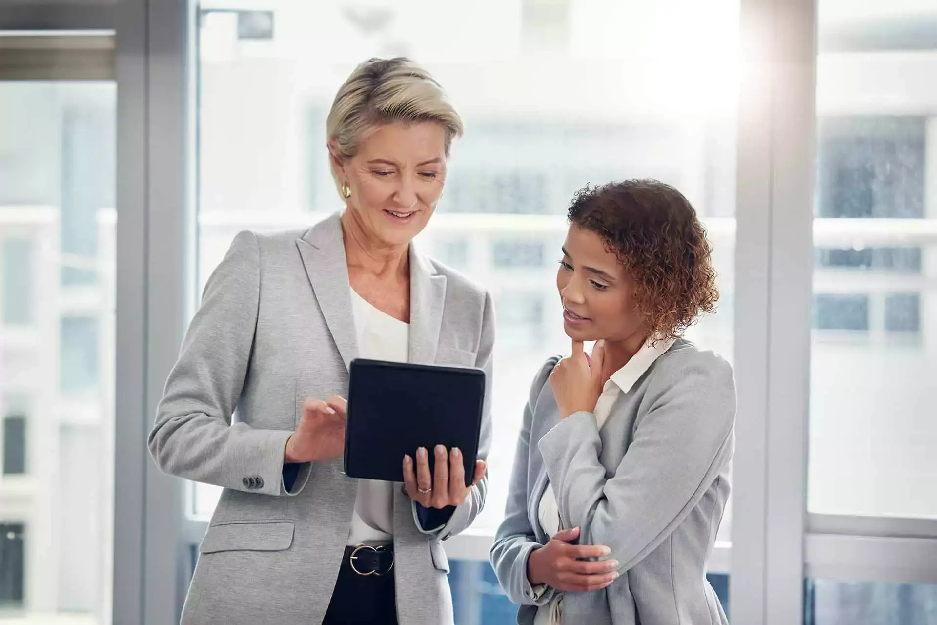 Two businesswomen looking at the table on utilizing Lx Transaction Management