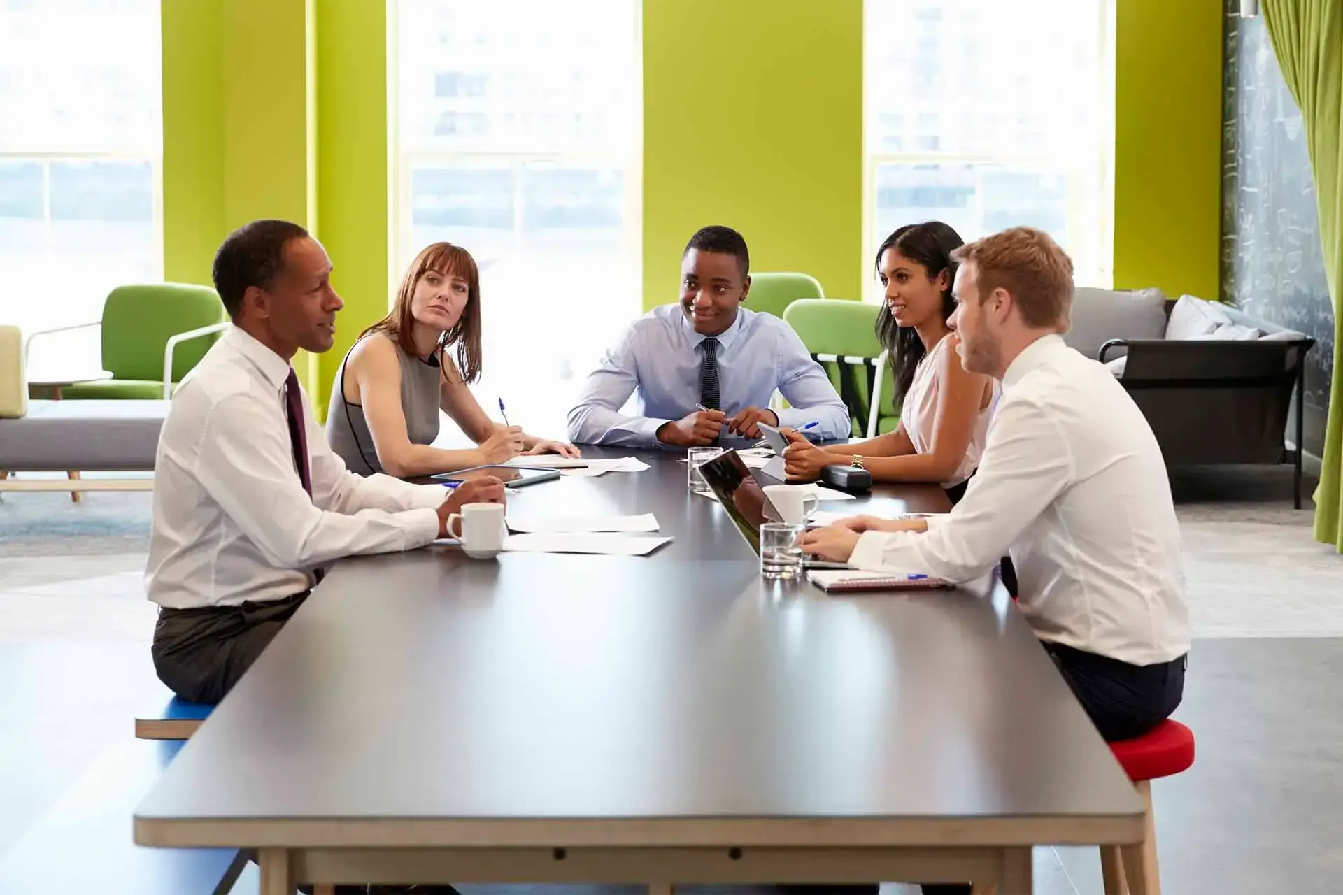 Employee using desk and room booking software to connect with colleagues in an office setting.