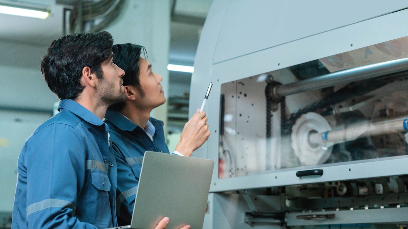 Two professionals preforming a maintenance check on machinery.